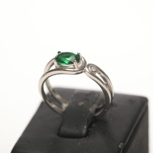 srebrni prsten na kojem je smaragdni zeleni kristal